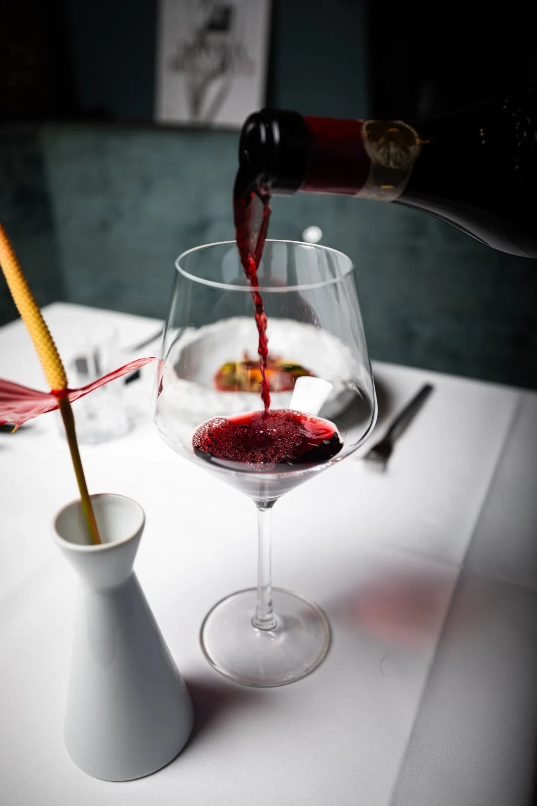 Bellucci Berlin – Rotwein wird am elegant gedeckten Tisch eingeschenkt, Fine-Dining-Atmosphäre im italienischen Restaurant